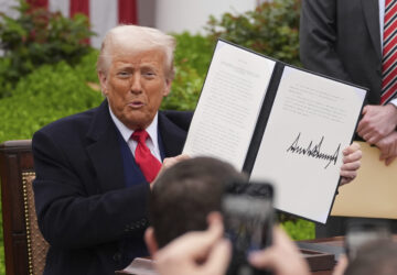 President Donald Trump holds a signed executive order during an event to announce new tariffs in the Rose Garden of the White House, Wednesday, April 2, 2025, in Washington. (AP Photo/Evan Vucci)
