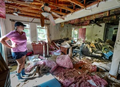 Cindy White looks over the devastation inside her home caused by Hurricane Helene, Oct. 1, 2024 in Morganton, N.C. The adjacent Catawba River flooded due to the torrential rains destroying the seven of family’s nine homes on the property. (AP Photo/Kathy Kmonicek)