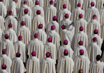 A bishop uses a smartphone as Pope Francis presides over a mass in St. Peter's Square, at the Vatican, for the opening of the second session of the 16th General Assembly of the Synod of Bishops, Oct. 2, 2024. (AP Photo/Gregorio Borgia)