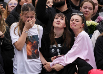 Fans react as they gather near the Peter Pan statue in Hyde Park, London, to pay tribute to late British singer Liam Payne, former member of the British pop band One Direction, Oct. 20, 2024. (AP Photo/Scott A. Garfitt/Invision)