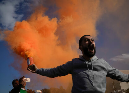 A man waves a flare during a celebratory demonstration following the first Friday prayers since Bashar Assad's ouster in Damascus’ central square, Syria, Dec. 13, 2024. (AP Photo/Leo Correa)